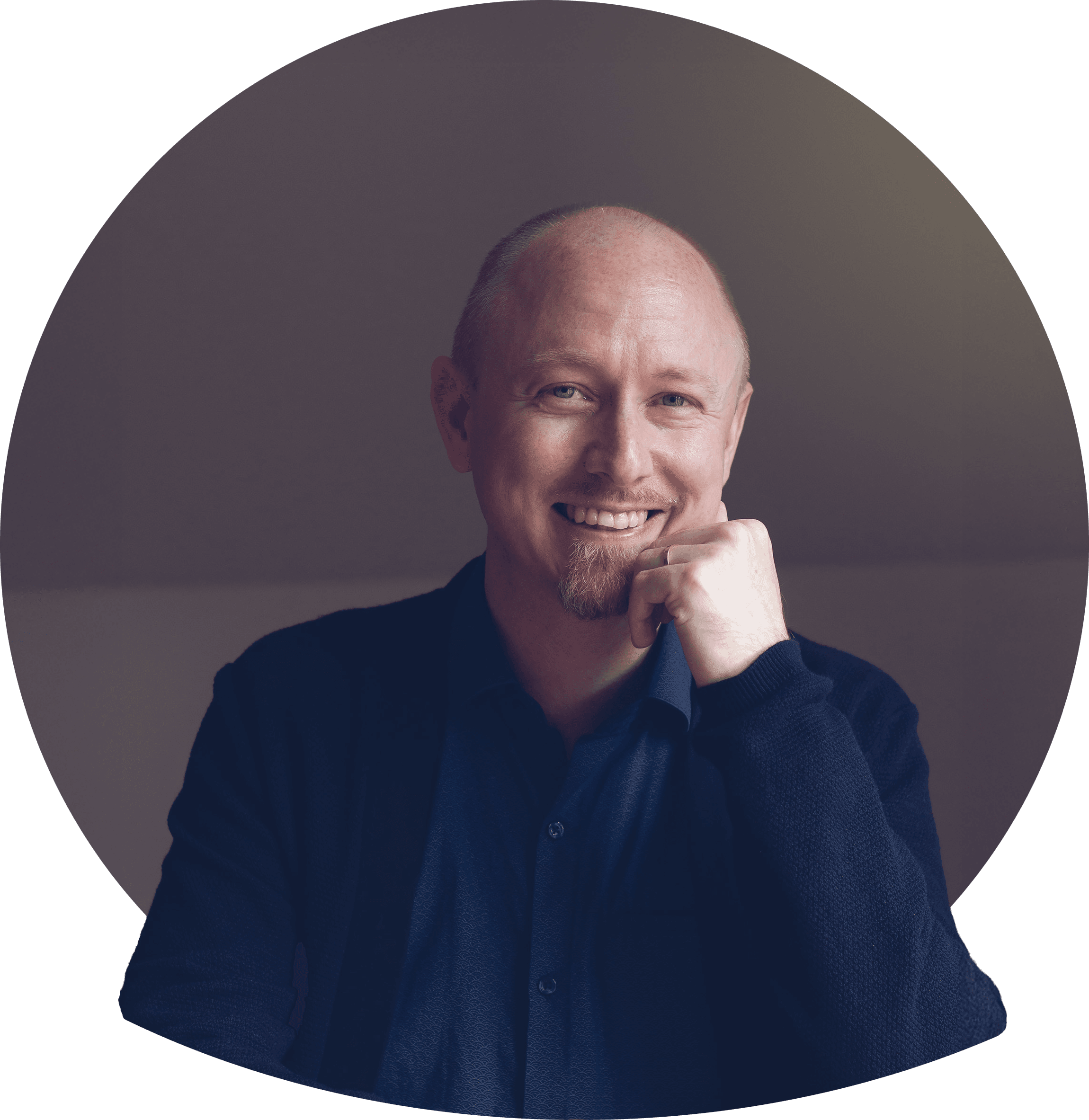 Danne smilende med kort blondt hår og skjegg i mørk blazer og lys t-skjorte. Foto.