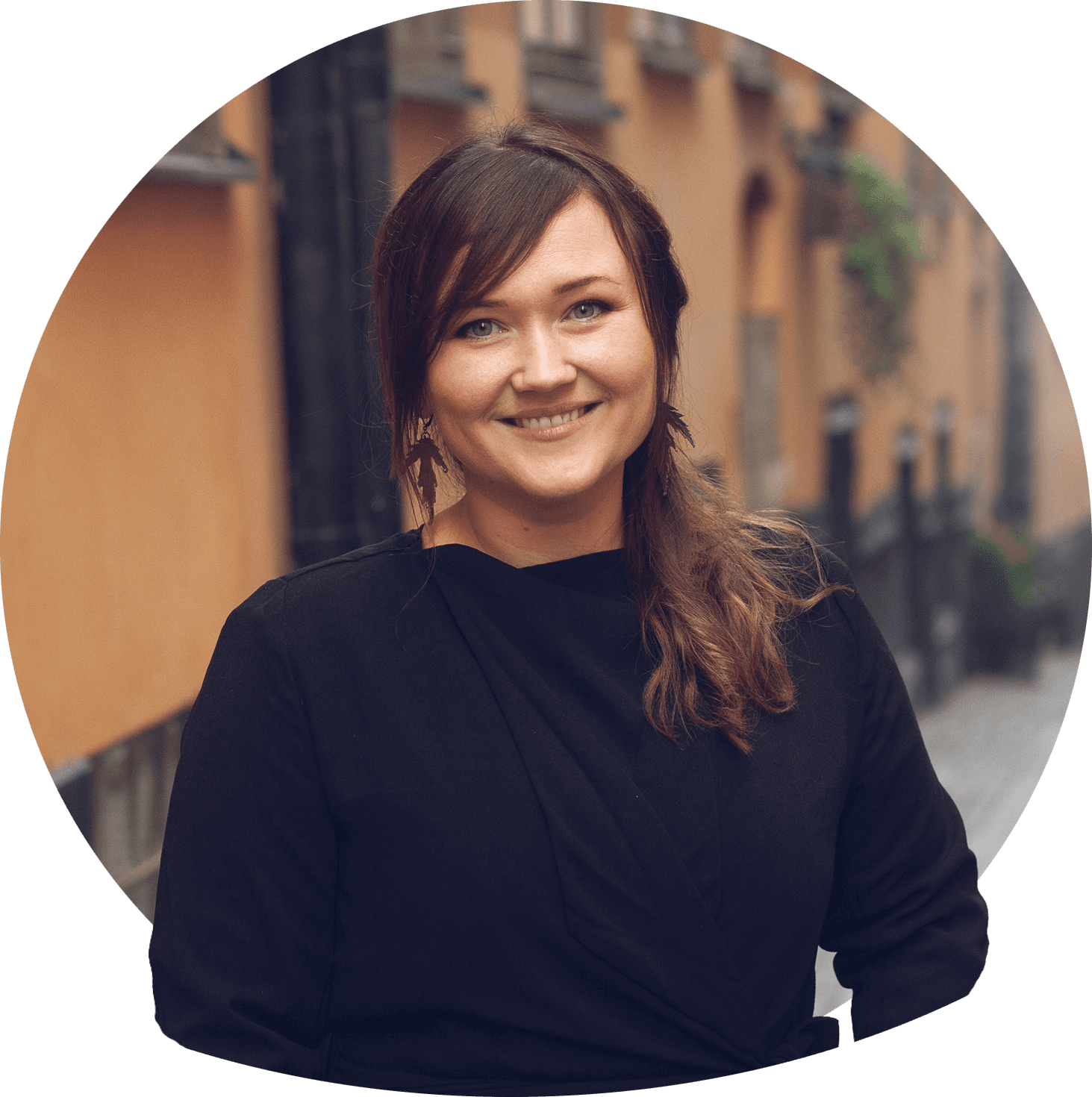 Moa smilende med skulderlangt svart hår, svart jumper over hvit bluse med krage. Foto.